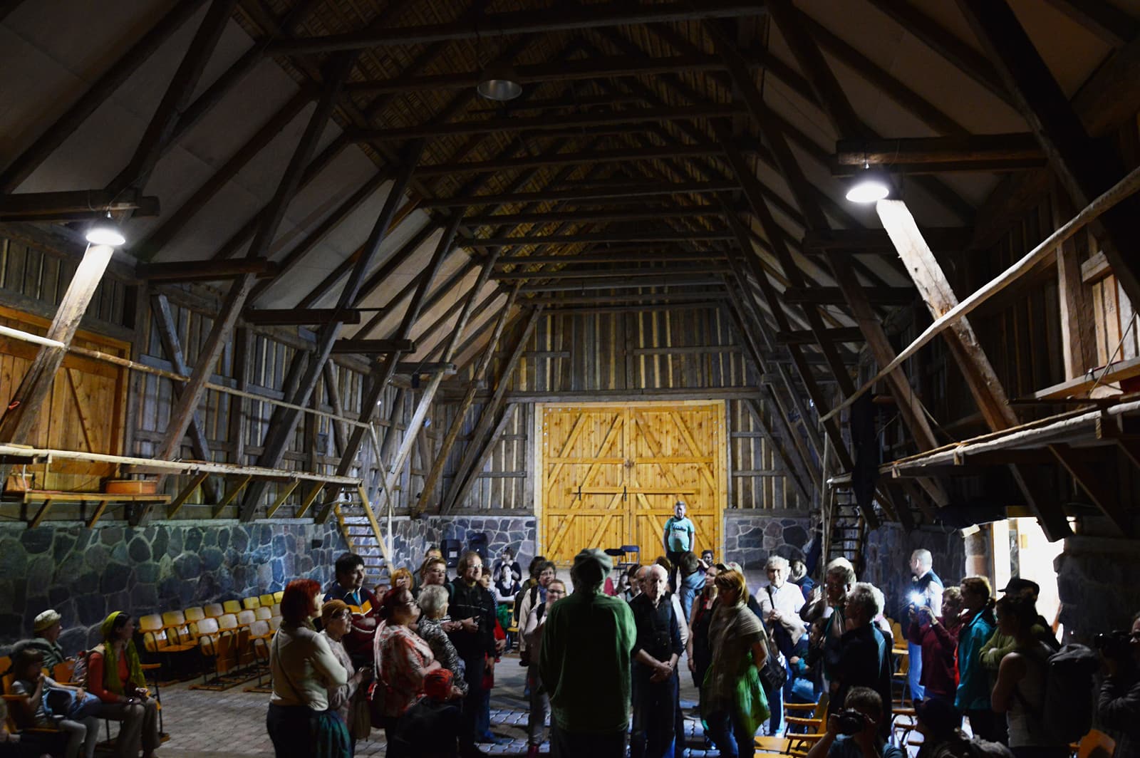 An audience gathered inside the timber-roofed Omari barn on Naissaar