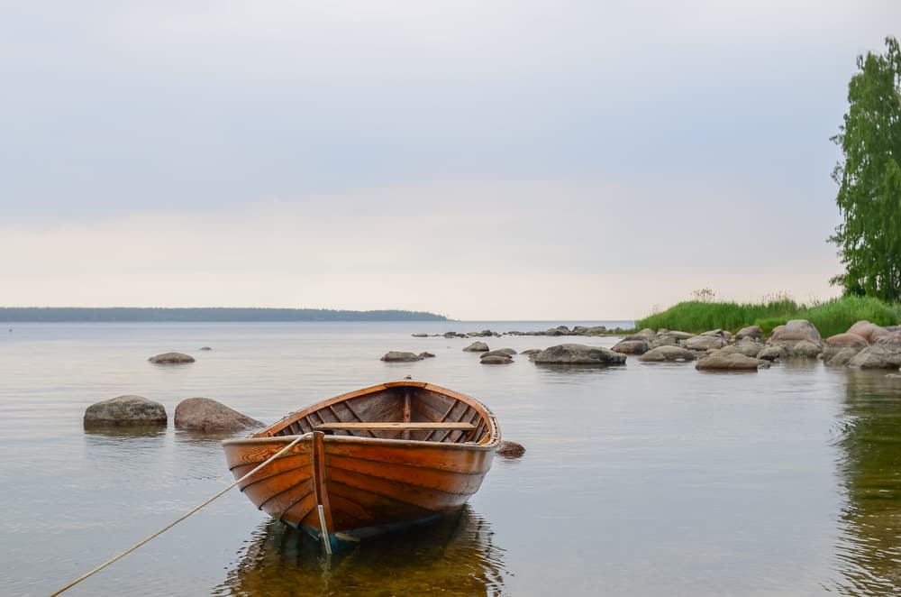 A wooden rowing boat moored among boulders on the coast at Käsmu in Lahemaa